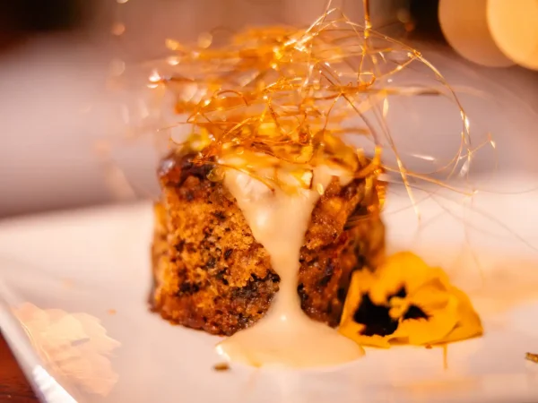 A rich dessert pudding topped with spun sugar and edible flowers served at Khamab Game Reserve.